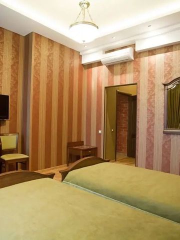 Geschmackvoll eingerichtetes Zimmer mit zwei Einzelbetten und gestreifter Tapete