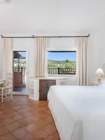 Helles Hotelzimmer mit Terrakottafliesen und Balkon mit Blick auf die Natur