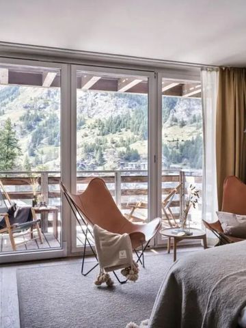 Helle Suite mit Blick auf die Berge und gemütlicher Sitzecke auf Balkon