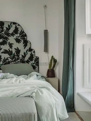 Modern eingerichtetes Hotelzimmer mit elegantem Kopfteil und grünen Akzenten