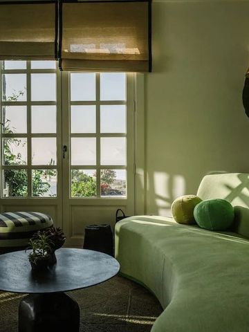 Lounge mit geschwungener Sofalandschaft und großen Fenstern