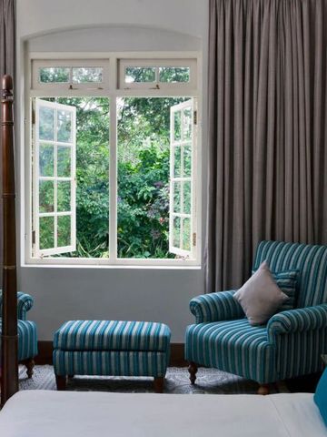 Heller Sitzbereich mit großen Fenstern und Blick auf üppiges Grün