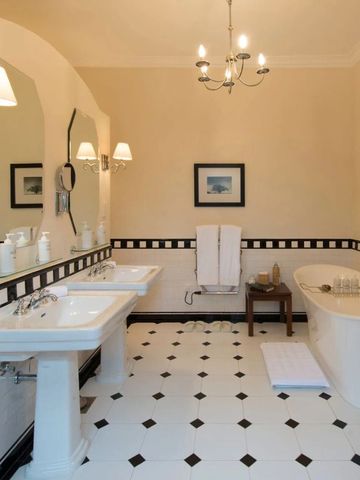 Elegant eingerichtetes Badezimmer mit freistehender Badewanne und Doppelwaschbecken