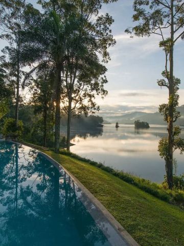Eindrucksvoller Infinity-Pool mit Blick auf einen ruhigen See und Bäume.