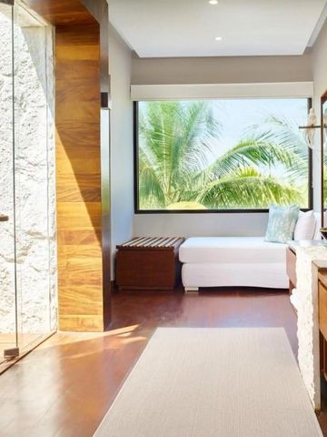 Geräumiges Badezimmer mit großer Dusche und Ausblick auf Palmen