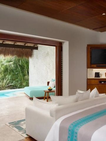 Suite mit Poolzugang und komfortablem Sofa im Vordergrund.