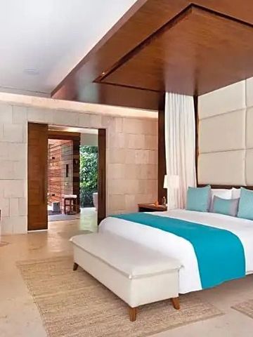 Geräumiges Schlafzimmer mit blau-weißer Bettgarnitur und holzvertäfelter Decke.