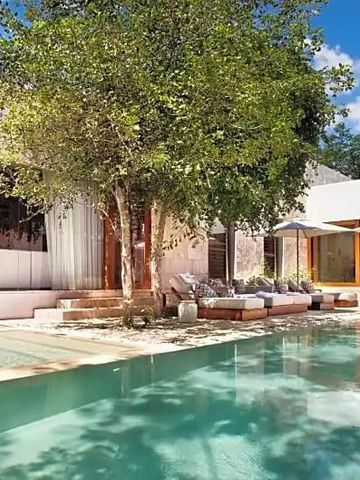 Villa mit Terrasse und Pool umgeben von üppigen Bäumen und Pflanzen