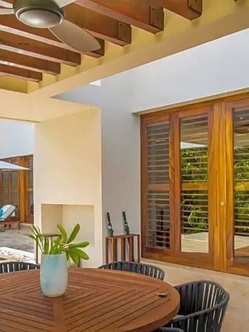 Überdachte Terrasse mit Sitzbereich und Ausblick auf den Pool in einer Villa