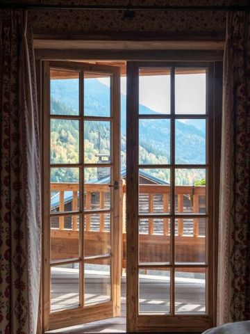 Blick vom Chalet auf die malerischen Berge durch eine verglaste Holztür