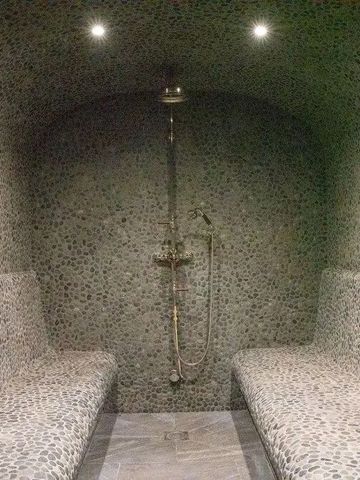 Luxuriöse Sauna aus Steinfliesen und Sitzgelegenheiten