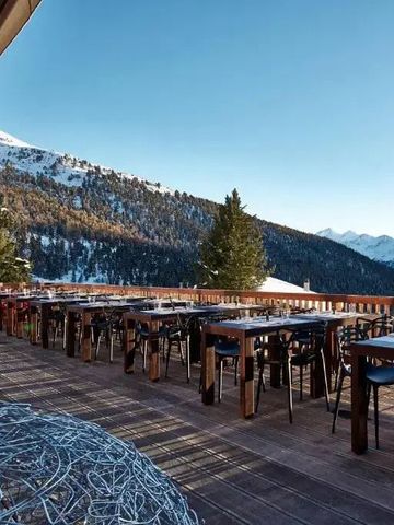 Außenterrasse mit Bergblick und Holzmöbeln im Sonnenlicht
