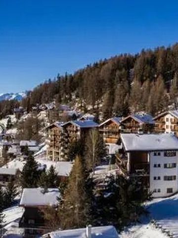 Schneebedecktes Bergdorf mit Chalets und blauer Himmel