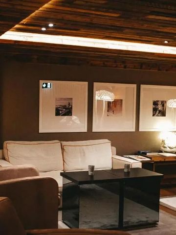 Gemütliche Lounge mit Sofas und Holzwänden, stimmungsvolle Beleuchtung