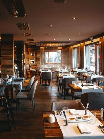 Elegantes Restaurant mit gedeckten Tischen und großen Fenstern