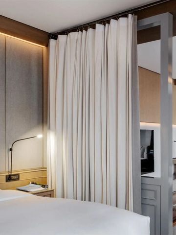 Gemütliches Doppelzimmer mit modernen Annehmlichkeiten und Vorhängen