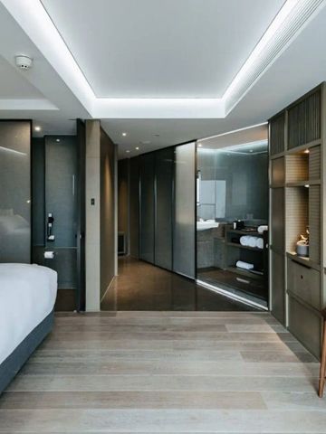 Geräumiges modernes Hotelzimmer mit Schreibtisch und luxuriösem Bett in sanften Tönen