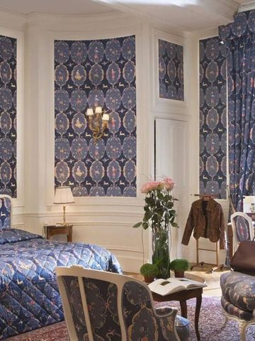 Opulentes Zimmer mit blauer Tapete und luxuriösen Möbeln.