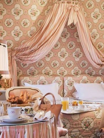 Gemütliches Zimmer mit rosa Dekor und reichhaltigem Frühstück auf dem Tisch.