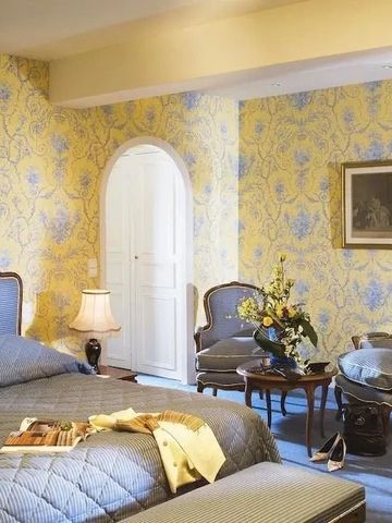 Elegantes Schlafzimmer mit blauer Tapete und stilvollen Möbeln.