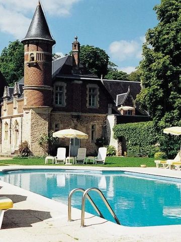 Historisches Schloss mit elegantem Pool und Liegestühlen im Garten.