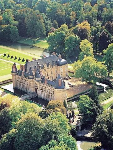 Luftaufnahme eines prächtigen Schlosses umgeben von üppigem Grün.