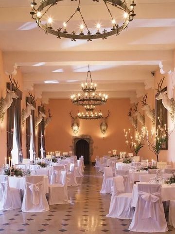 Prunkvoller Festsaal mit Jagdtrophäen und edlen Kronleuchtern.