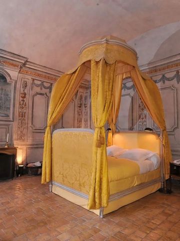 Königliches Schlafzimmer mit gelbem Baldachinbett und kunstvoll dekorierten Wänden