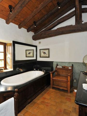 Luxuriöses Badezimmer mit freistehender Badewanne und Holzbalkendecke