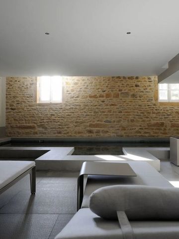 Moderner Spa-Bereich mit Liegen und einem Pool, Steinwände im Hintergrund