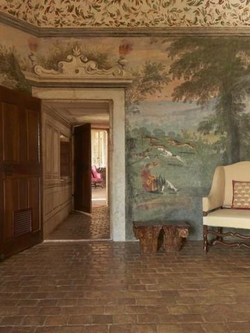 Historischer Raum mit kunstvoll bemalten Wänden und Holzmöbeln