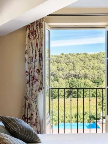 Helles Schlafzimmer mit offenem Fenster und Blick auf idyllische Landschaft.