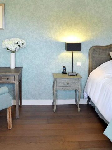 Elegantes Schlafzimmer mit pastellgrüner Wandgestaltung und Vintage-Möbeln.