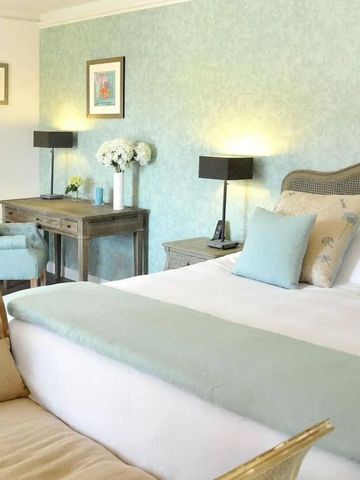 Geräumiges Doppelzimmer mit hellen Farben und klassischen Möbeln.