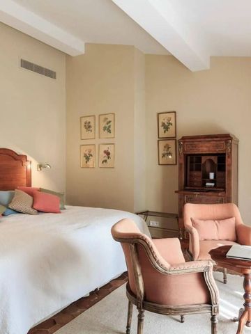 Ruhiges Schlafzimmer mit antiken Möbeln und dezenten Farbtönen.