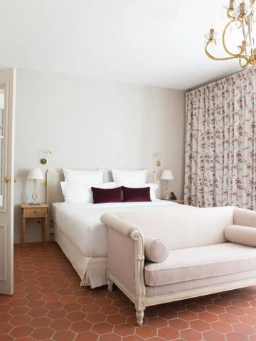 Geräumiges Zimmer mit Sitzgelegenheit und elegantem Kronleuchter.