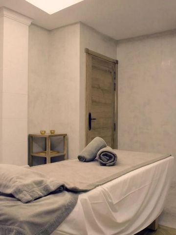 Luxuriöser Spa-Behandlungsraum mit Handtüchern auf Massageliege.