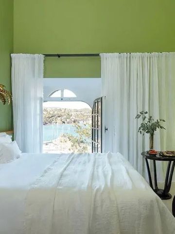 Grünes Schlafzimmer mit Zugang zum Balkon und Meerblick