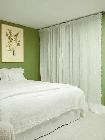 Gemütliches Hotelzimmer mit grüner Wanddekoration und weißem Bett