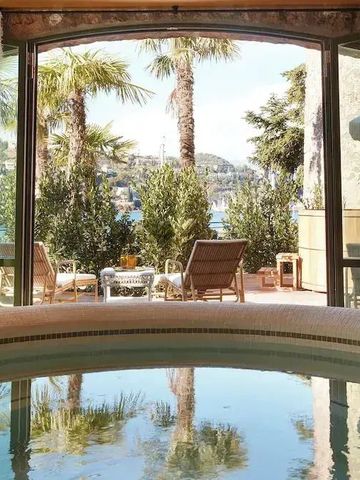 Panoramafenster mit Blick auf eine Terrasse mit Palmen und See