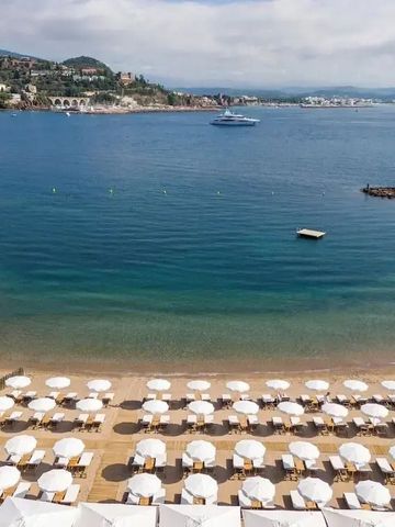 Sandstrand mit Sonnenschirmen und Blick auf das Meer in Theoule
