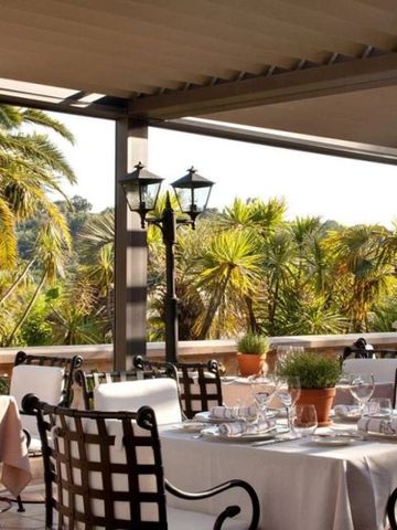 Restaurant-Terrasse mit edlen Tischgedecken und üppiger Vegetation