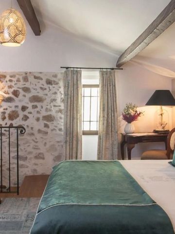 Charmantes Zimmer mit rustikaler Steinwand und schicken Dekorelementen im Château Eza Hotel