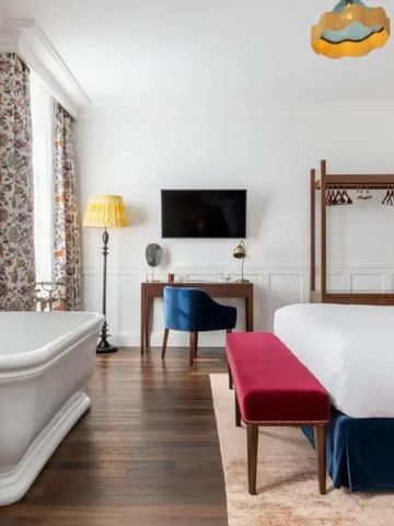 Elegantes Hotelzimmer mit Badewanne, Schreibtisch und Dekor im klassischen Stil