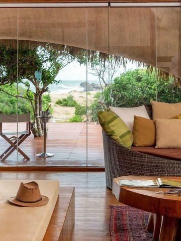 Luxuriöse Suite mit Terrasse und Blick auf tropische Vegetation und Meer