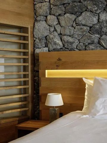 Bett mit Holz- und Steinelementen im Zimmer