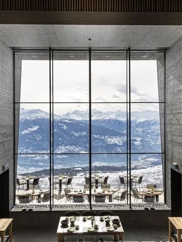 Geräumiges Restaurant mit großer Fensterfront und Blick auf verschneite Berge