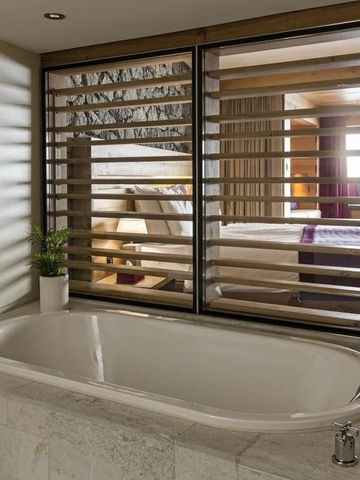 Luxuriöse Badewanne mit Blick in ein stilvolles Schlafzimmer.