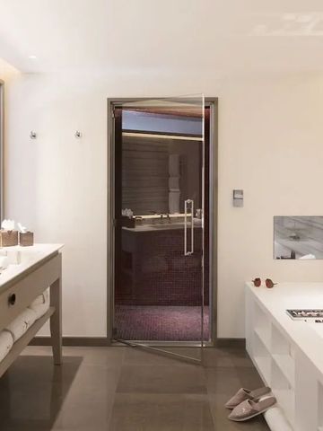 Helles Badezimmer mit Badewanne, großem Spiegel und modernen Elementen