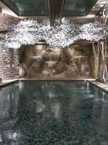 Luxuriöser Innenpool mit kunstvoller Deckenbeleuchtung und natürlichem Stein.